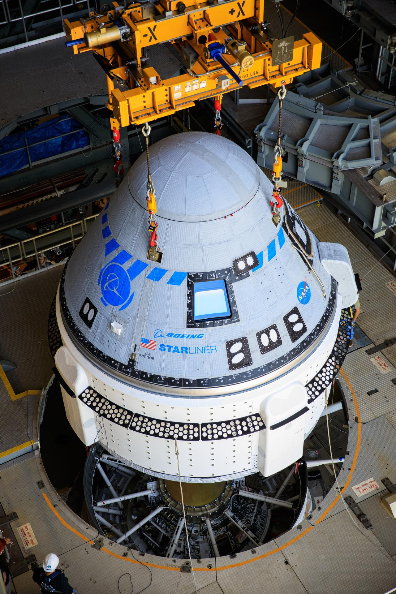 An aerospace load monitoring system lifts the Boeing CST-100 Starliner spacecraft at the Vertical Integration Facility at Space Launch Complex-41 at Florida's Cape Canaveral Space Force Station