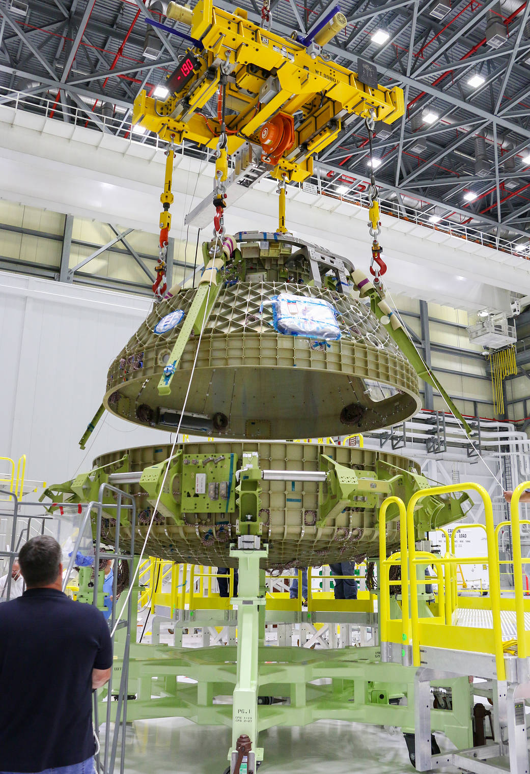 Engineers guide the upper dome of a Boeing CST-100 Starliner, connecting it to the lower dome.